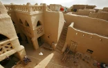 Une femme se repose dans la cour intérieure d'une vaste maison construite en terre battue, le 9 février 2005 à Djenné, dans le centre du Mali