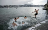 Des baigneurs plongent dans les eaux du détroit du Bosphore, dans le quartier de Bebek, à Istanbul, le 22 février 2025