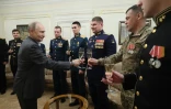 Photo transmise par l'agence officielle russe Sputnik montrant le président Vladimir Poutine portant un toast avec des militaires des forces armées russes, le 1er janvier 2024 à Novo-Ogaryovo, près de Moscou