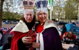 Des inconditionnels de la famille royale portent des masques du roi Charles III et de la reine consort Camilla, le 5 mai 2023 à Londres