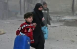 Des Syriens courent se mettre à l'abris pendant des bombardements du régime sur les zones rebelles dans la Ghouta orientale, le 6 mars 2018