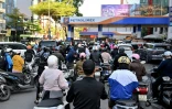 Des motocyclistes font la queue pour faire le plein d'essence dans une station-service à Hanoï, le 10 mars 2026 au Vietnam