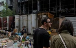 Des vendeurs du marché aux puces de Potchaïna endommagé par une frappe russe, à Kiev, le 9 août 2026 en Ukraine
