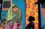 Une femme passe devant une peinture murale réalisée par un collectif d'artistes transgenres à Bombay le 22 février 2022