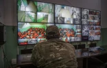 Un combattant des Forces démocratiques syriennes (FDS) surveillent sur des écrans les jihadistes présumés entassés dans une prison kurde du nord-est syrien, le 26 octobre 2019
