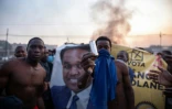 Des manifestants exhibent une munition de gaz lacrymogène devant une banderole à l'effigie de Venancio Mondlane à Maputo le 24 octobre 2024