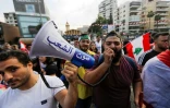 Mégaphone en main, des manifestants libanais défilent contre le pouvoir à Zouk Mosbeh, au nord de Beyrouth, le 20 octobre 2019 