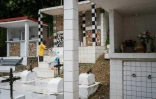 Un membre de la famille Vainqueur décore une tombe dans le cimetière privé de la famille aux  Abymes, en Guadeloupe, le 31 octobre 2025