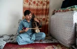 Le musicien afghan Wahid Nekzai Logari joue du "sarinda", un instrument local, dans sa maison de Kaboul le 22 juillet 2024