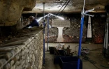Un ouvrier construit un mur avec des ossements humains lors des travaux de restauration des Catacombes de Paris, le 24 mras 2026