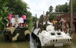 Des habitants transportent sur un camion de l'armée le cercueil d'une victime d'un glissement de terrain pendant des inondations à Bulathsinhala, le 27 mai 2017 au Sri Lanka