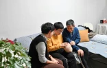 Zhang Yachun (c), entourée de son père et de sa mère, parle avec son robot Aluo, doté d'une intelligence artificielle, le 7 janvier 2025 à Pékin