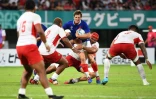 Le demi de mêlée Baptiste Serin (c) plaqué par les Tongiens durant le match de poules du Mondial, à Kumamoto, le 6 octobre 2019