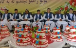 De futurs époux afghans attendent, devant des gâteaux, le début d'une cérémonie de mariage collectif à Kaboul, le 13 juin 2022