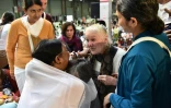 Une femme vient d'être étreinte par la gourou indienne Mata Amritanandamayi (g), connue sous le nom de "Amma", lors d'un rassemblement à Paris, le 26 octobre 2016