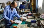 Des artisans travaillent sur la restauration de Corans anciens ou abimés dans un atelier de Tripoli, le 22 mars 2022 en Libye