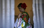 Une femme se prépare à défiler pour les fêtes de la Saint-Antoine dans le quartier de l'Alfama à Lisbonne, le 12 juin 2022