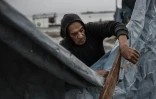 Un homme nettoie sa tente abßmée par la pluie, dans le quartier de Zeitoun à Gaza-ville le 11 décembre 2025