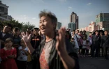 Des spectateurs entourent une retraitée, Ryu Ri Hwa, interviewée par l'AFP après une déclaration télévisée du dirigeant nord-coréen Kim Jong-Un, près de la gare centrale de Pyongyang, le 22 septembre 2017.