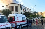 Des ambulances et des responsables de la sécurité sont regroupés à l'extérieur du ministère des Affaires étrangères libyen à Tripoli où a lieu une attaque, le 25 décembre 2018