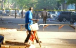 Un cycliste regarde les soldats postés devant le quartier général des forces armées à Ouagadougou, le 3 mars 2018