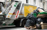 Un camion-poubelle passe à côté de poubelles débordantes de déchets à Paris le 8 juin 2016
