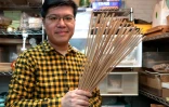 Aaron Tang avec des batons d'encens faits à la main, dans son atelier le 23 janvier 2025, à Hong Kong