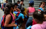Des gens se battent pour récupérer de la nourriture sur le sol d'un marché de rue à Caracas, le 10 mars 2019