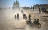Des Palestiniens marchent le long de la route côtière dans le centre de la bande de Gaza en direction de la ville de Gaza, dans le nord, le 11 octobre 2025