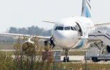 Un homme quitte l'Airbus A-320 de la compagnie EgyptAir qui stationne sur le tarmac de l'aéroport de Larnaca à Chypre le 29  mars 2016 après son détournement