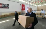 Photo fournie par le service de presse de la présidence tunisienne montrant le président tunisien Kais Saied participant à une distribution d'aide en pleine crise du coronavirus le 5 avril 2020 à Gammarth, en banlieue nord de la capitale Tunis