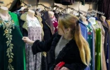 Une femme regarde des vêtements nationaux dans une boutique du bazar Korvon, à Douchanbé, le 2 décembre 2024 au Tadjikistan