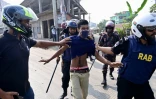 Un ouvrier du textile (c) arrêté pendant une manifestation contre l'augmentation jugée "ridicule" de leur salaire minimum, le 9 novembre 2023 à Gazipur, au Bangladesh