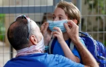 Un père ajuste le masque de sa fille le jour de la rentrée scolaire, le 1er septembre 2020 à Tel Aviv