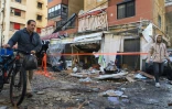 Des habitants marchent sur des débris près d'un immeuble touché par une frappe israélienne à Saïda, dans le sud du Liban, le 4 avril 2025