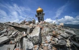 Une partie d'une mosquée effondrée surgit des décombres laissés par un puissant séisme suivi d'un tsunami dans le quartier de Perumnas Balaroa à Palu, sur l'île des Célèbes en Indonésie, le 6 octobre 2018