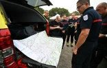 Des pompiers consultent une carte à n Saint-Laurent-de-la-Cabrerisse, dans l'Aude, où un incendie a parcouru quelque 16.000 hectares dans le massif des Corbières, le 8 août 2025