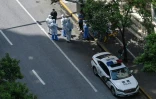 Un véhicule de police et des fonctionnaires en combinaison intégrale de protection contre le Covid-19 dans un quartier confiné de Shanghai, le 8 mai 2022