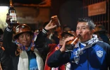 Des mineurs boivent de la bière lors d'une cérémonie de sacrifice de lamas dans une minde d'Oruro, en Bolivie, le 25 février 2022