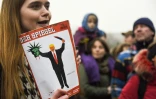 Une femme tient une édition du magazine "Der Spiegel", où figure une illustration de l'artiste américano-cubain Edel Rodriguez, lors d'une manifestation contre un décret anti-immigration de Donald Trump, le 4 février 2017 à Berlin