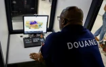 Un douanier français scanne le bagage d'un passager se rendant à Paris à l'aéroport international Félix-Eboué de Cayenne, le 24 mars 2024