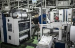 Un employé surveille le processus d'impression à l'imprimerie Kyoto Shimbun à Kumiyama, dans la préfecture de Kyoto, le 19 mars 2026 au Japon