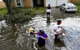 Des habitants évacuent leur maison inondée après le passage de l'ouragan Ida, le 30 août 2021 à LaPlace, en Louisiane