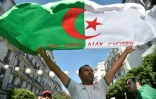 Un Algérien agite un drapeau national lors d'une manifestation contre la classe dirigeante dans la capitale Alger le 27 septembre 2019, pour le 32e vendredi consécutif depuis le début de la contestation