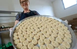 Eftali Qerimi montre un plateau de loukoums d'amande à l'eau de rose dans son atelier à Përmet, le 28 mai 2025 en Albanie