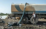 Un ouvrier à côté d'un générateur pompant de l'eau du lac Dembel pour remplir un camion-citerne pour une entreprise de construction chinoise, le 21 mai 202 à Batu, en Ethiopie 