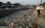 Un canal d'évacuation des égoûts rempli de déchets plastiques dans le bidonville Taimur Nagar à New Delhi le 30 mai 2018