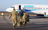 Des soldats danois montent à bord d'un avion lors d'un déploiement à la base aérienne de Karup, le 11 mars 2022 au Danemark