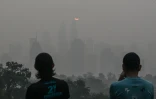 Deux personnes se tiennent devant la capitale malaisienne saturée de fumées toxiques, à Kuala Lumpur, le 17 octobre 2026