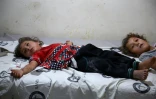 Deux fillettes syriennes blessées par des bombardements sont allongées sur un lit d'hôpital dans le nord de la province d'Idleb, le 20 août 2019